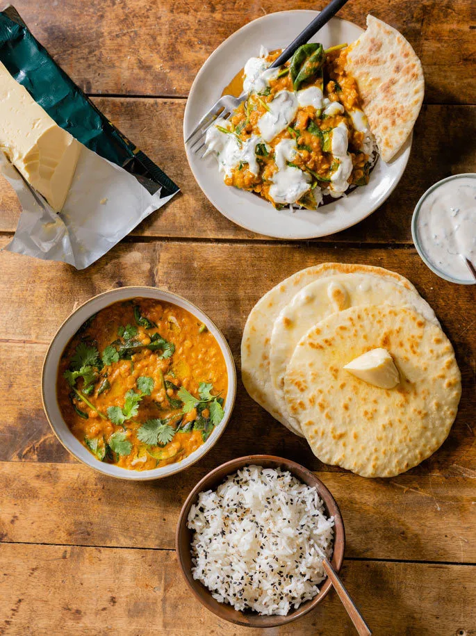 Intialainen dal, naanleipää, raita-kastiketta ja riisiä